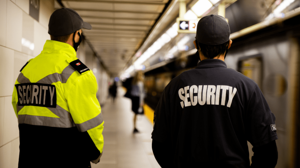 two security guards standing in a subway station