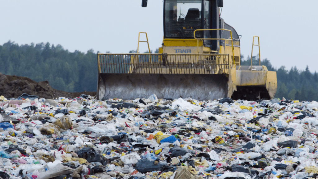 a bulldozer is in the middle of a pile of garbage