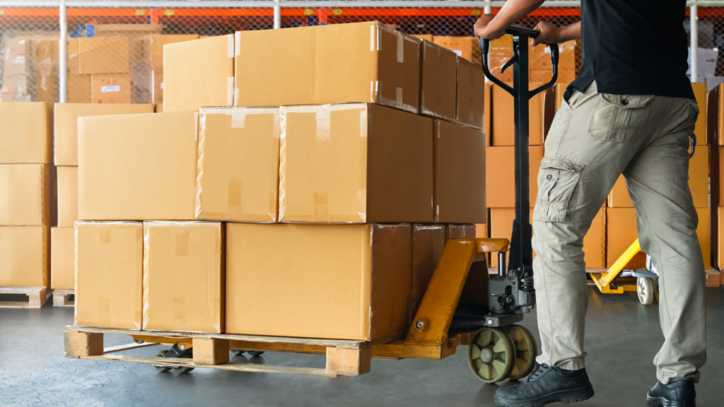 a person pushing a cart with boxes in a warehouse