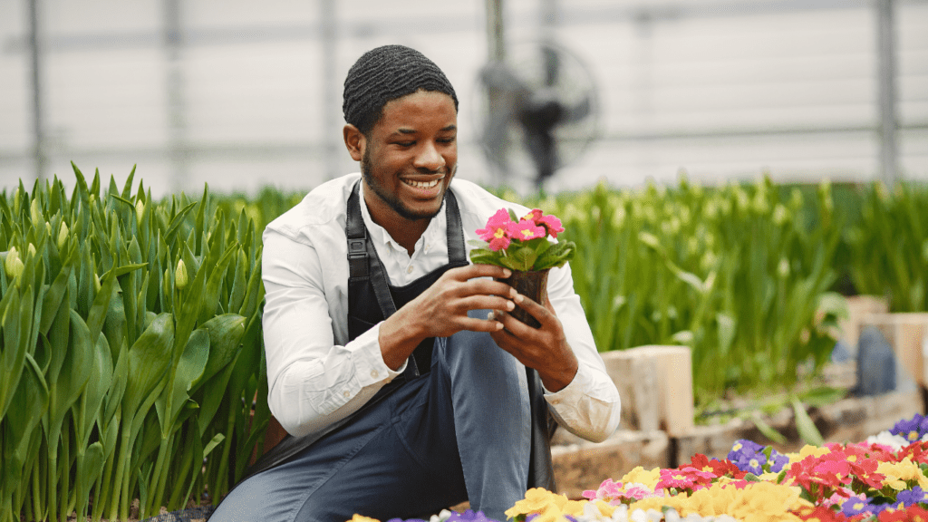 a happy man looking to his plant