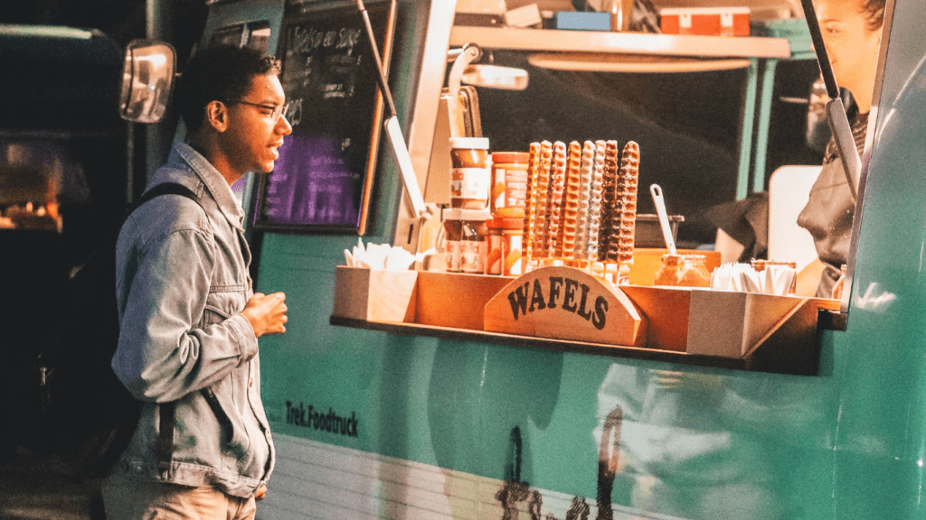 Two people standing in front of a food stand