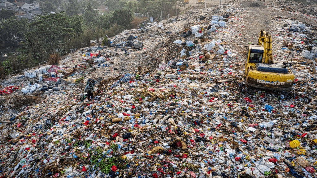 a bulldozer is in the middle of a pile of garbage