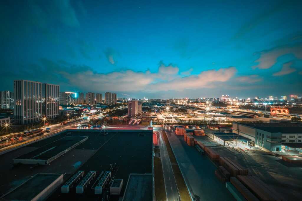 Vivid urban cityscape at night showcasing bright lights and clouded sky, perfect for travel and architectural themes.